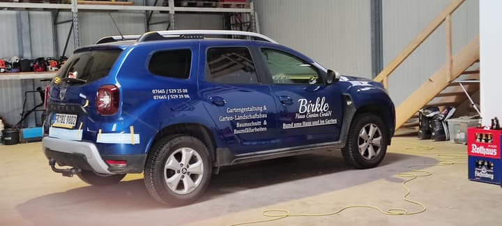 Blauer SUV mit Beschriftung auf Türen und Seitenfläche
