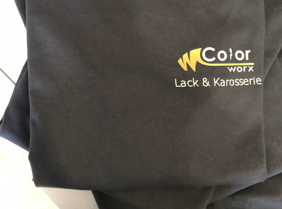 Dunkles T-Shirt mit veredeltem Firmenlogo auf der Brust