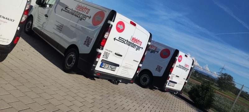 Drei weiße Transporter eines Elektrobetriebs mit einheitlicher Beschriftung
