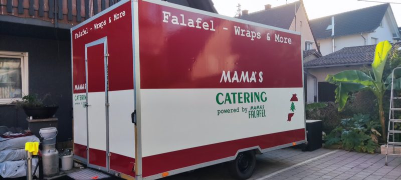 Rot-weißer Catering-Anhänger mit Logo und Schriftzug