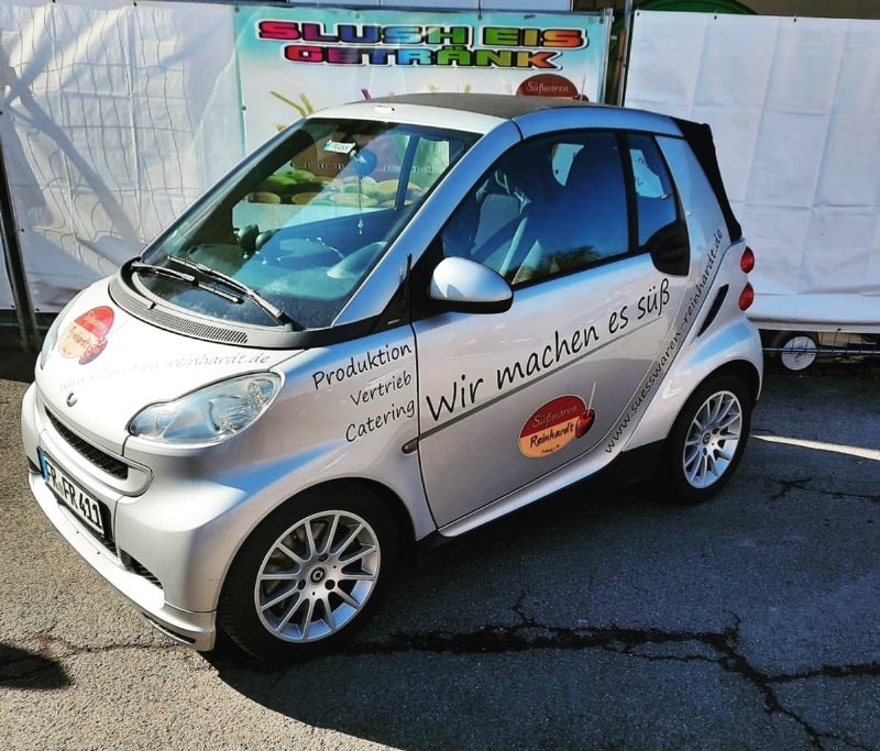Silberner Smart mit Logo, Leistungen und Slogan
