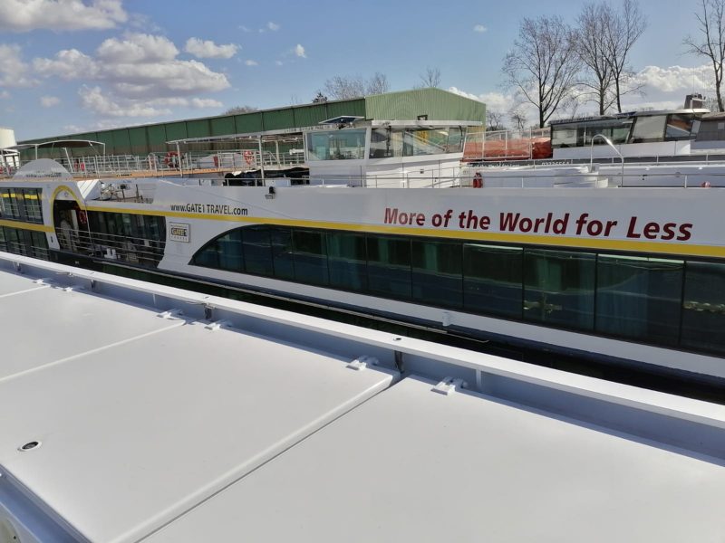 Flusskreuzfahrtschiff mit Slogan an der Bordwand