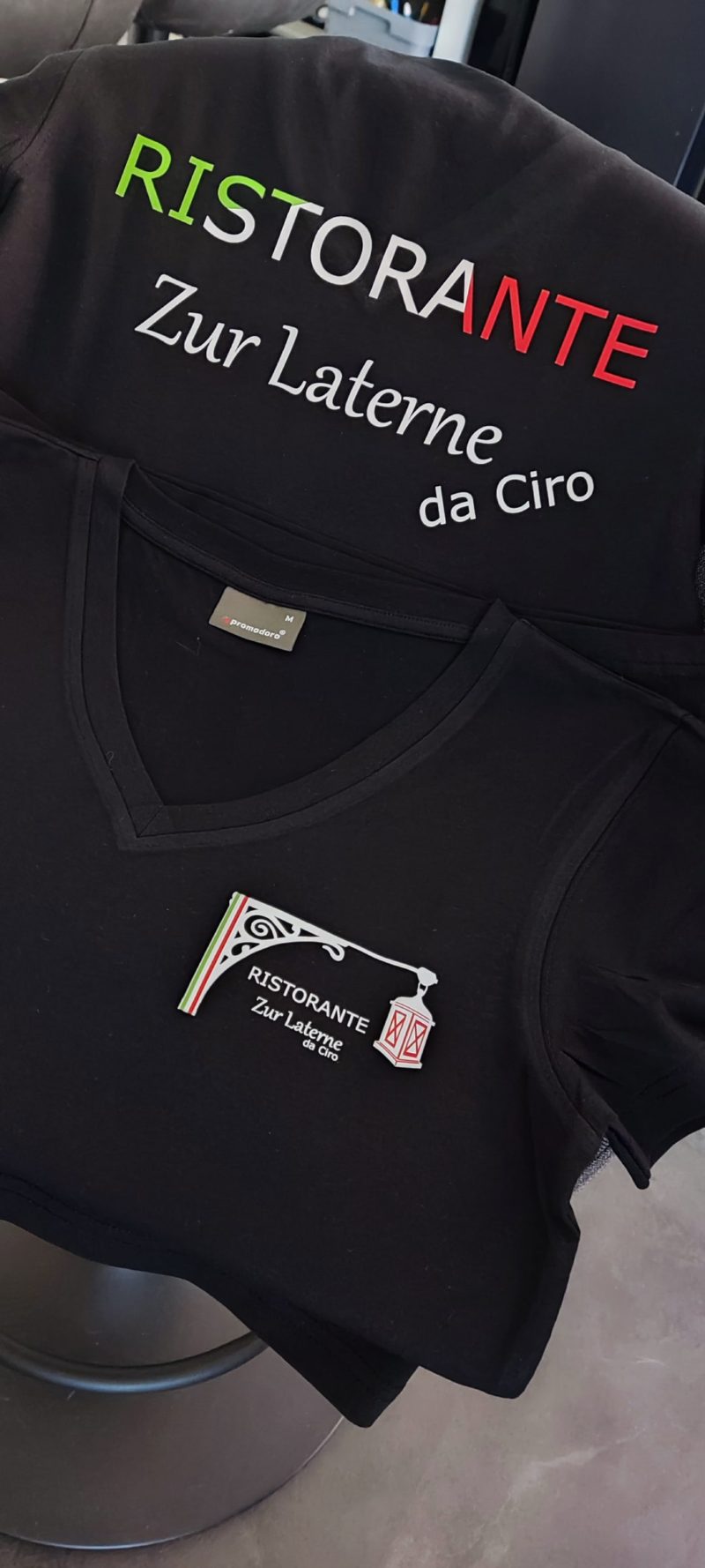 Schwarzes Shirt mit Restaurant-Schriftzug und Logo