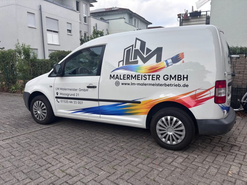 Weißer VW Caddy eines Malerbetriebs mit Logo, farbigem Verlauf und Kontaktdaten