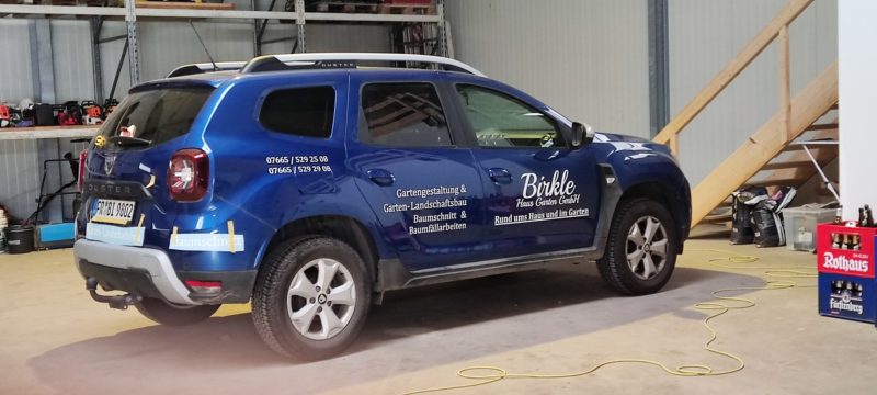 Blauer SUV mit weißer Beschriftung auf den Türen